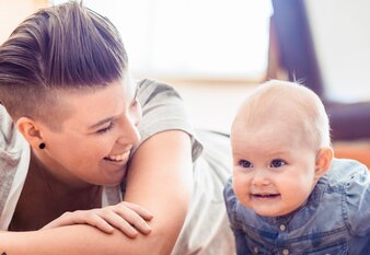 Regenbogenfamilie: zwei junge Frauen mit einem Baby