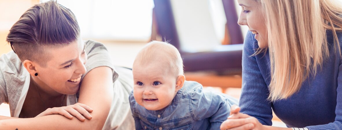 Regenbogenfamilie: zwei junge Frauen mit einem Baby