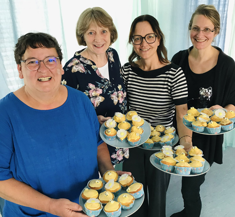 4 Fachberaterinnen präsentieren gelbe Muffins
